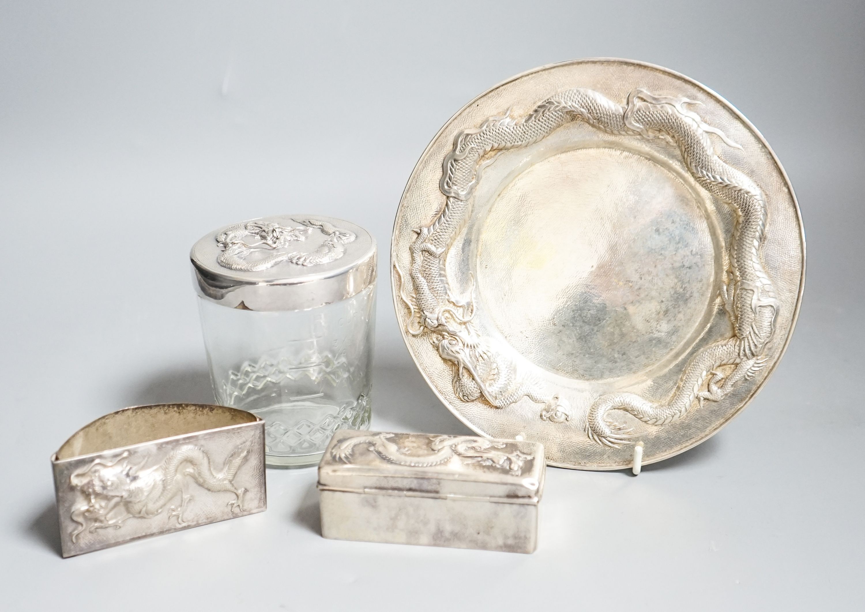 A Chinese white metal dish by Wang Hing, 18.4cm and a similar rectangular box, a white metal mounted jar by Tack Hing and an unmarked blotter.